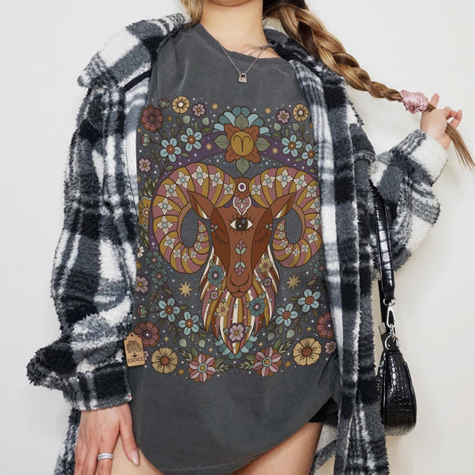 Person wearing a dark gray sweatshirt with a colorful ram design, standing against a plain background.