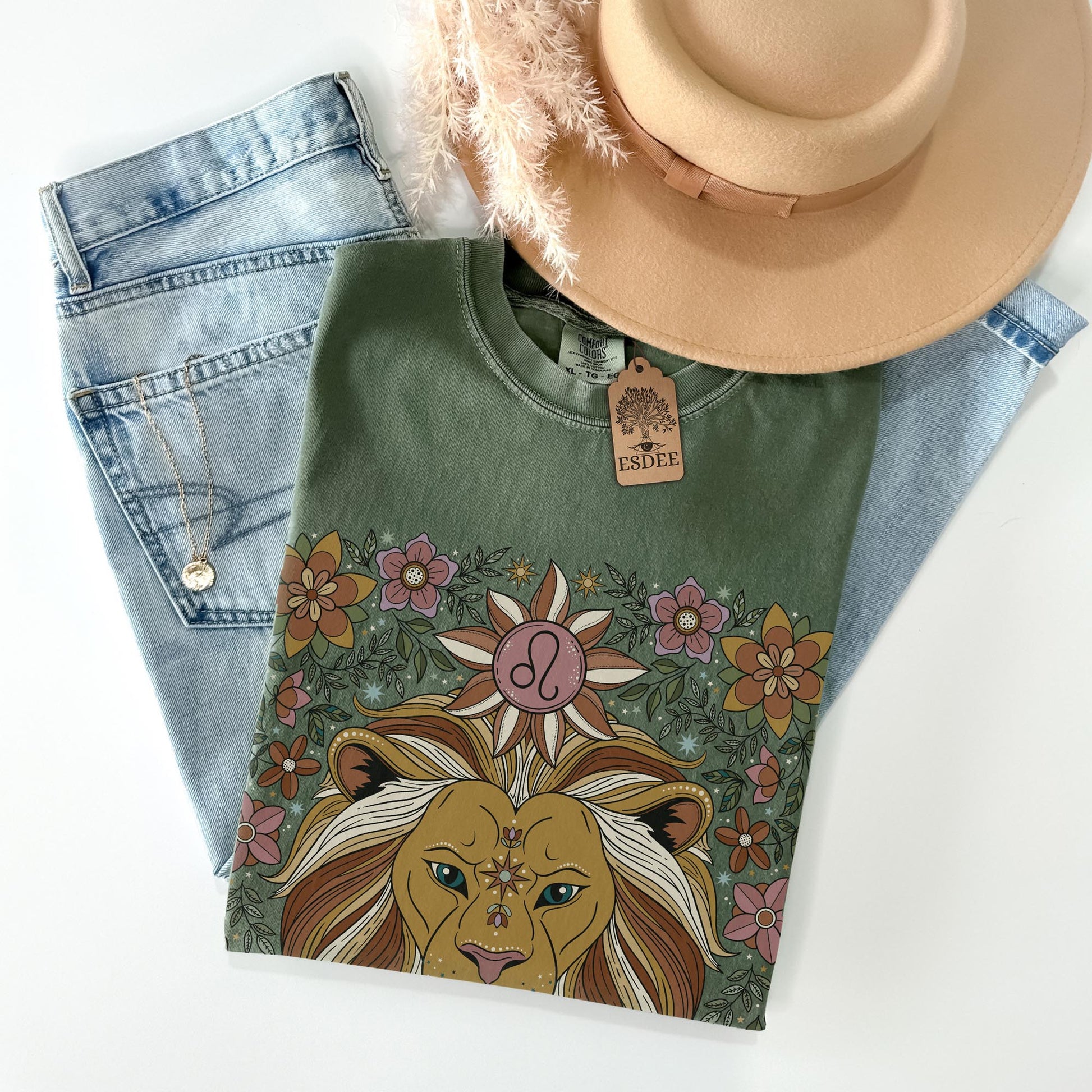 Green t-shirt with lion design, denim jeans, and beige hat on a white background