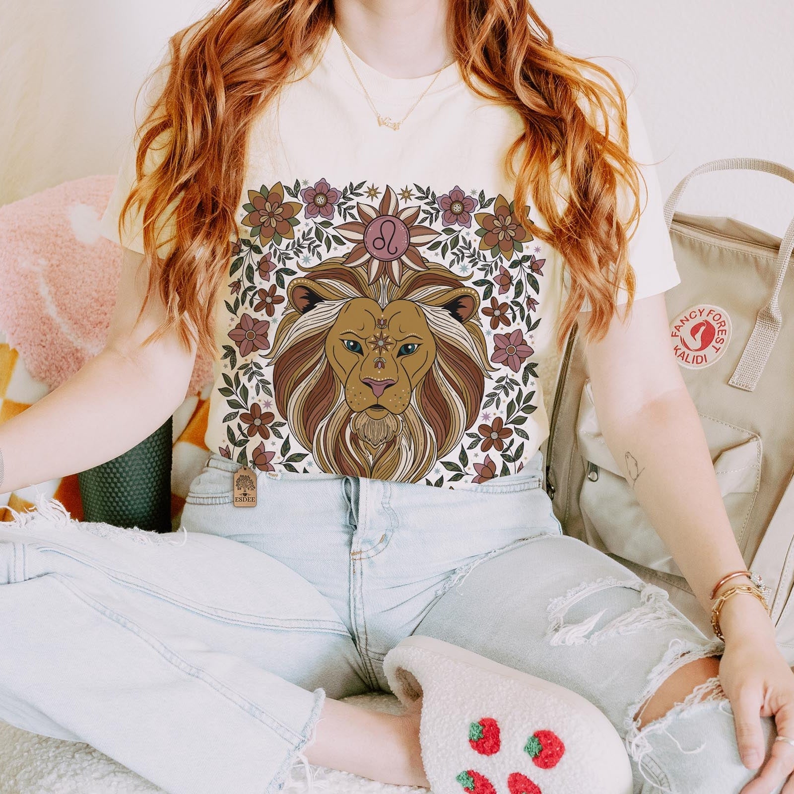 Person wearing a t-shirt with a lion design, sitting on a chair.