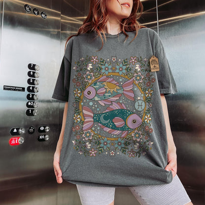 Person wearing a gray t-shirt with a colorful fish design in an elevator.