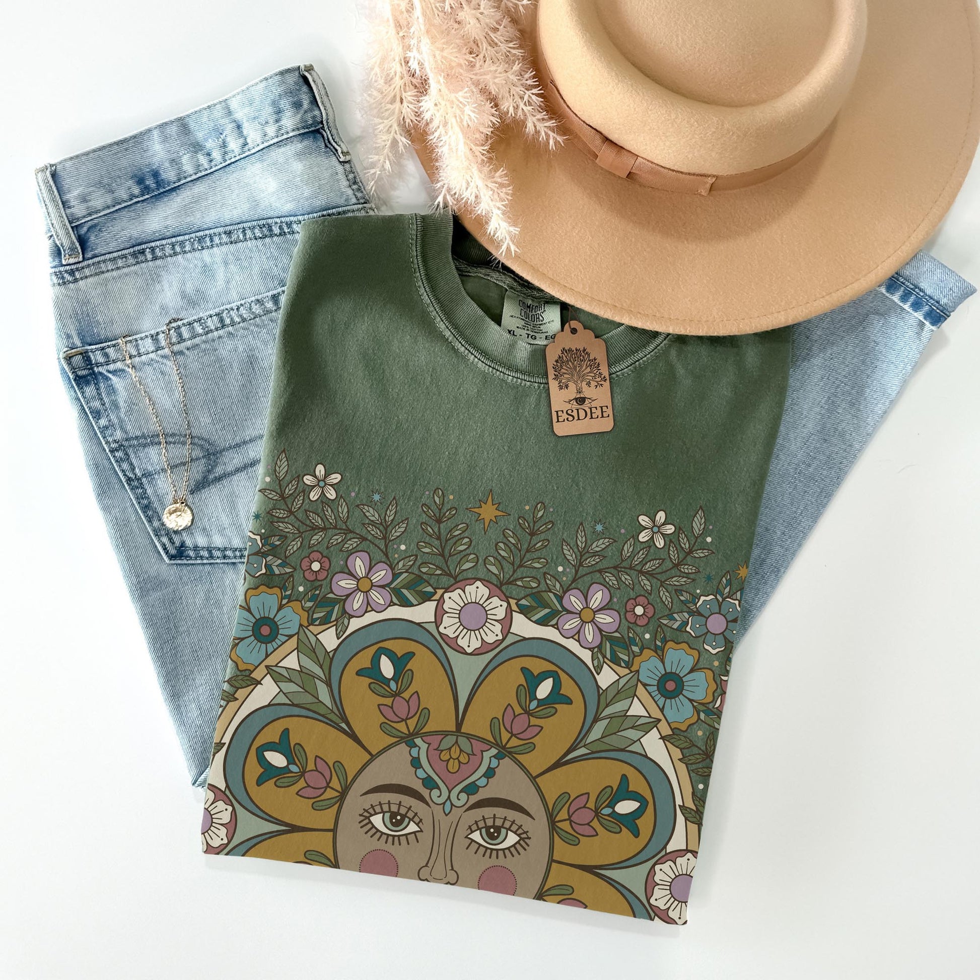 Green sweatshirt with floral design, jeans, and a hat on a white background
